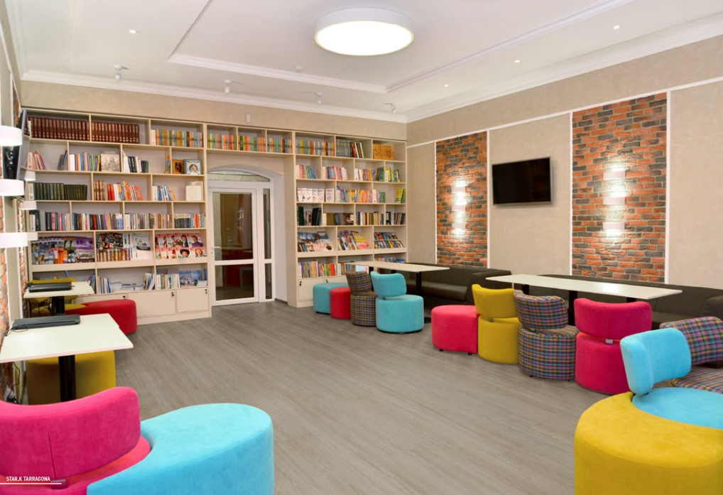 grande salone con libreria cuscini e pavimento vinilico effetto legno